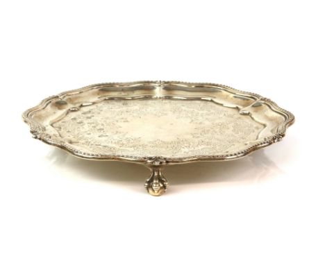 Victorian silver salver, the shaped circular body with beaded rim and chased centre, on three ball and claw feet, London 1877