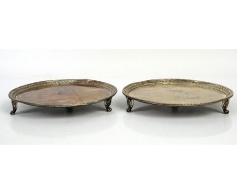 George III pair of silver waiters, the centres engraved with crest with bead and leaf embossed borders, each on three shell c