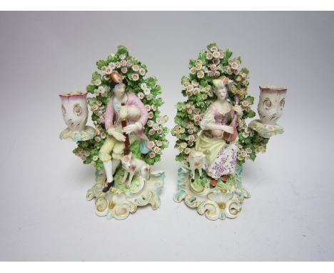 "Pair of Derby Candlestick Figures of musicians with mandolin and bagpipes, painted costume with bocage backgrounds on blue a