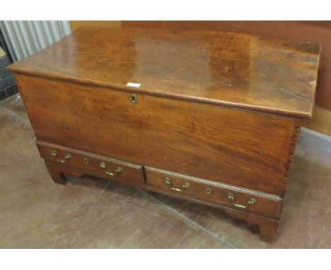 "An 18th Century elm Mule Chest with hinged lid above two short drawers on shaped bracket feet, 3ft 10in wide"