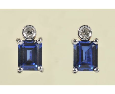 A pair of Diamond and Sapphire Earrings each set brilliant-cut diamonds above corner claw-set step-cut sapphire in 18ct gold