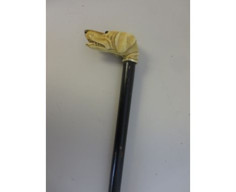 "An ebonised Walking Stick with carved ivory hounds head handle with glass eyes, 32in L"