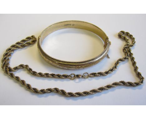 A 9ct gold hinged Bangle with scroll engraving and beaded rims and a 9ct gold rope twist Necklace