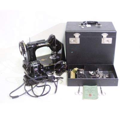 A vintage featherweight black singer sewing machine, model 221k in carry case with accessories. Comes with instruction manual