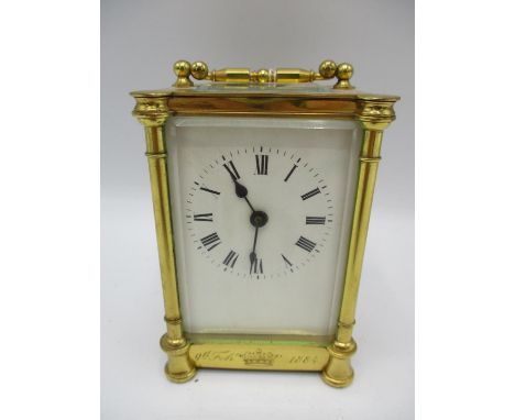 A late 19th century brass cased carriage clock having a white enamel dial with Roman numerals, the case dated to the front 9t