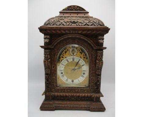 Circa 1900 an oak carved mantel clock, the arched top dial having a silvered chapter ring with Roman numerals and inscribed '