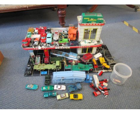 A tin plate vintage model garage with various Dinky, Matchbox and other diecast model vehicles, including a Corgi Toys James 