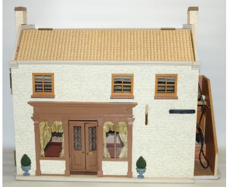 Three-room dolls house modelled as a cottage, with external staircase leading to the first floor, and lighting, floor and wal