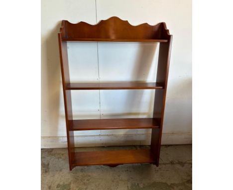 A mahogany veneered four shelf wall hanging shelving unit 