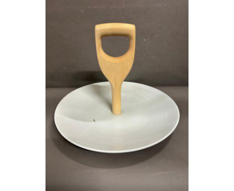 A white ceramic serving platter with a wooden shovel handle by Thorsten Van Elten 