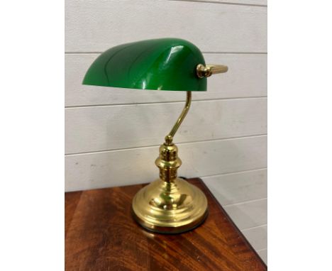 A brass bankers lamp with green shade