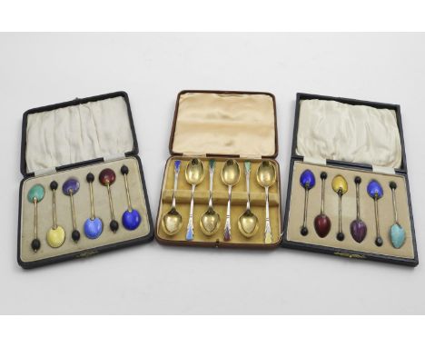 ENAMELLED COFFEE/TEASPOONS: A cased set of 6 silvergilt bean-end coffee spoons with coloured enamel on the back of the bowls,