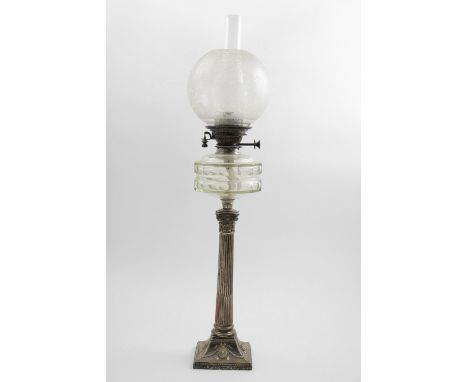 A LATE VICTORIAN ELECTROPLATED-MOUNTED COLUMN LAMP with a faceted glass reservoir, a glass shade and chimney, c.1900; 32.75" 