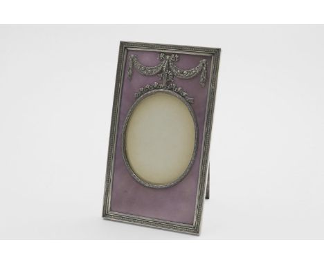 AN EARLY 20TH CENTURY SWEDISH PHOTOGRAPH FRAME rectangular with an oval window and easel stand, decorated with translucent ma