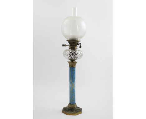 A VICTORIAN BRASS LAMP on an octagonal gothic base with a light blue overlaid glass column with cut decoration, a clear, cut 