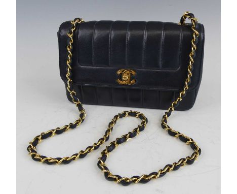 Coco Chanel - a navy leather 'Madamoiselle' quilted flap bag, having interwoven leather and gold toned metal chain strap, CC 