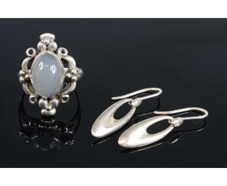 Georg Jensen - a sterling silver and moonstone set dress ring, the oval cabochon stone surrounded by floral stylised design, 