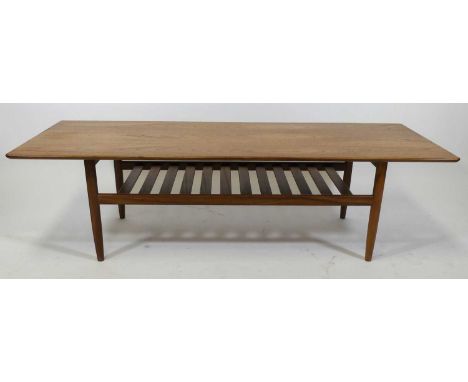A 1960s G-Plan teak long coffee table, having rounded corners, raised on plain turned tapering supports united by laddered un