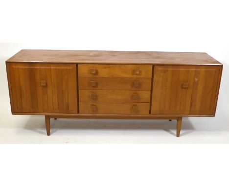 A 1960s British elm 'Ensign' sideboard by Bristow &amp; Townsend, having four central drawers, the upper drawer lined and fit