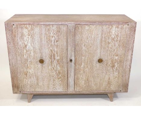 In the manner of Jean-Michel Frank - a 1930s French limed oak double door side cupboard, with brass dished pull handles, cent
