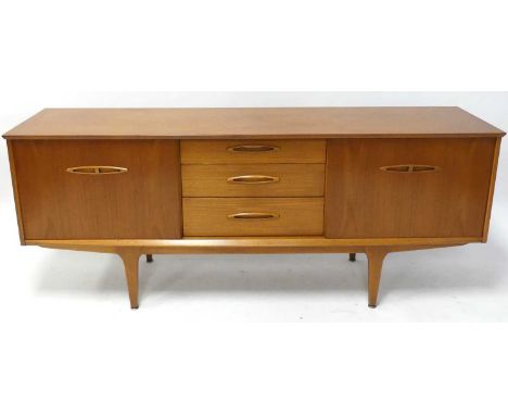 A 1960s Jentique teak long sideboard, having three central drawers flanked by sliding cupboard doors, with elliptical integra