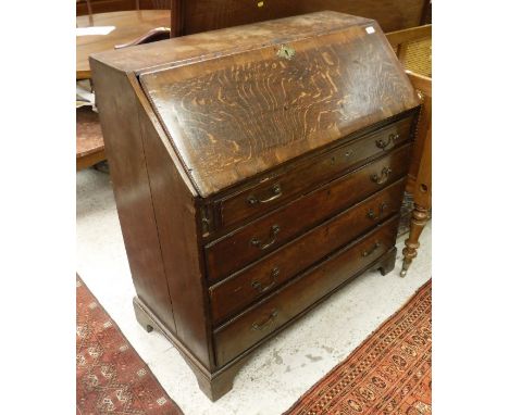 A George III oak and cross banded bureau, the fall front opening to reveal a fitted interior above four graduated drawers rai