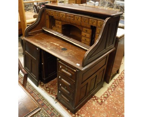 An early 20th Century oak roll top desk with fitted interior together with a oak Captain's style chair inscribed "ABCR" to ba