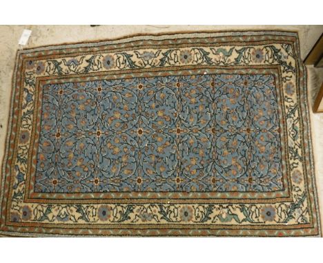 A Persian rug, the central panel set with all over floral decoration on a light blue ground, within a stepped light blue and 