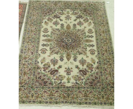 A Persian carpet, the central panel set with a stylised floral medallion on a cream ground, within a stepped stylised floral 