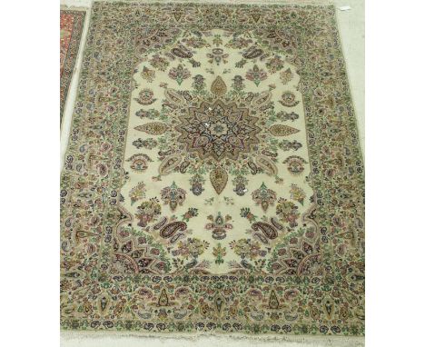 A Persian carpet, the central panel set with a stylised floral medallion on a cream ground, within a stepped stylised floral 