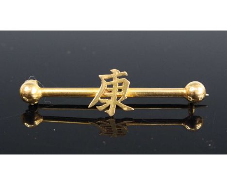 A yellow metal dumbbell bar brooch, set with Mandarin calligraphy, sponsor CW, numbered 12 but tests as approx 18ct gold, 28m