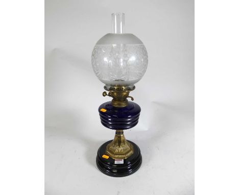 A late Victorian brass and glass pedestal oil lamp having acid etched shade and blue glass font, height 48cm