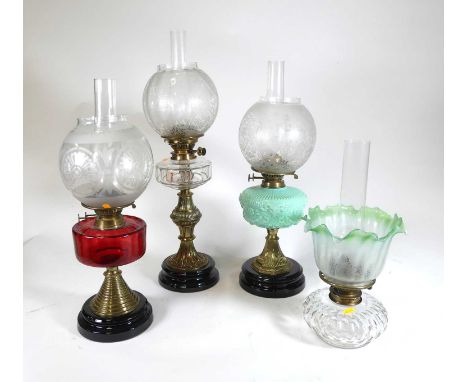 A Victorian brass pedestal oil lamp having acid etched spherical shade, faceted clear glass font, and raised on a black glaze