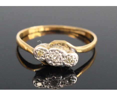 An 18ct gold and platinum diamond ring, arranged as three small illusion set round cuts in a raised line setting, size O, 2.3