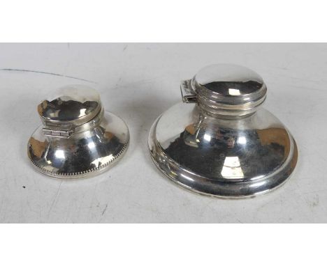 A George V silver capstan inkwell, with clear glass liner, on weighted base; together with another smaller example (2)