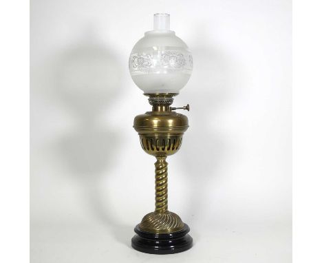 An early 20th century brass oil lamp having etched globular shade to a brass font on spirally turned column and domed base, h