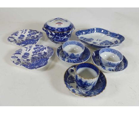 A collection of blue and white porcelain wares, to include a pair of tea bowls on stands, each in the Willow pattern, circa 1
