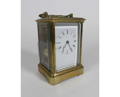 A circa 1900 lacquered brass carriage clock, having a visible platform escapement and white enamel dial showing Roman numeral