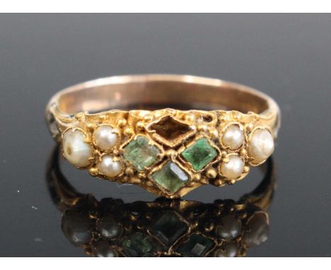 A Victorian and later yellow metal semi-precious set dress ring, the oval setting with seed pearls and three of four emeralds