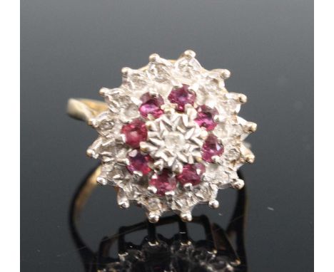 A 9ct gold ruby and diamond flower head cluster ring, arranged as three alternating tiers, the round cut diamonds all being i