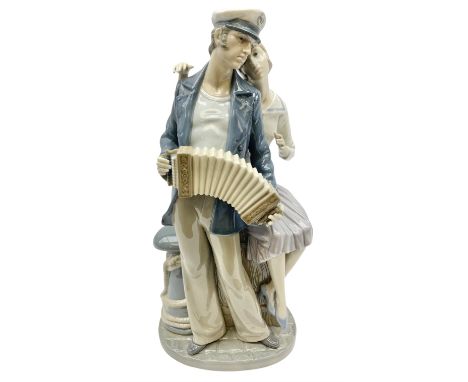 Lladro figure, Sailors Serenade, modelled as a sailor playing an accordion with a woman seated upon a crate, no 5276, year is