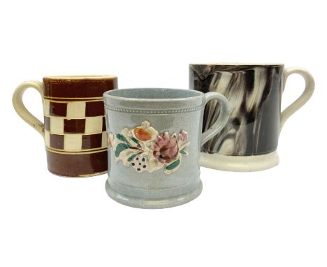 Three 19th century mochaware type cups, comprising an engine turned cream and brown checkerboard example, together with a mar