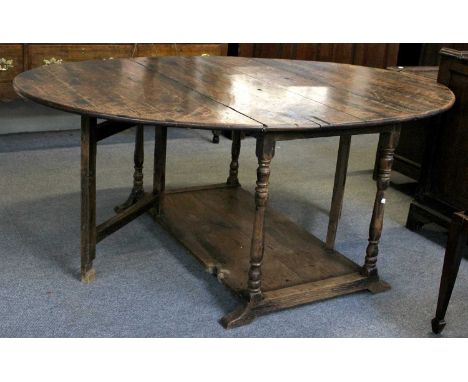 An 18th Century Oak Gate Leg Dining Table, with turned and block supports and a pot board stretcher, 182cm by 122cm by 71cm