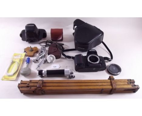 A Nikon camera body, wooden tripod and other camera equipment