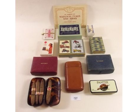 A box of collectables including playing cards, cigarette cards, photography items, a 'tortoiseshell' cigar case and a leather