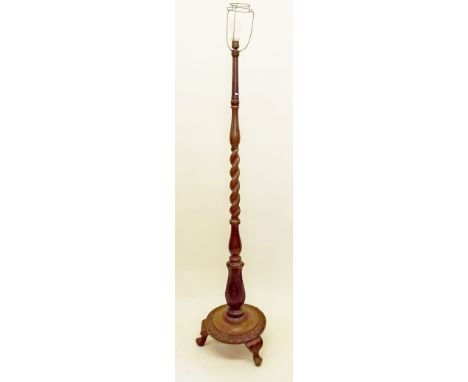 A spiral turned standard lamp with carved base and triple cabriole supports