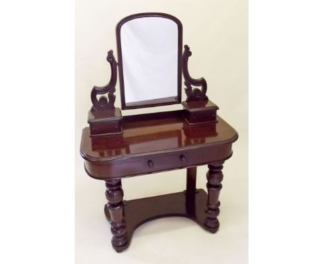 A Victorian small mahogany dressing table with trinket drawers over frieze drawer all raised on turned supports
