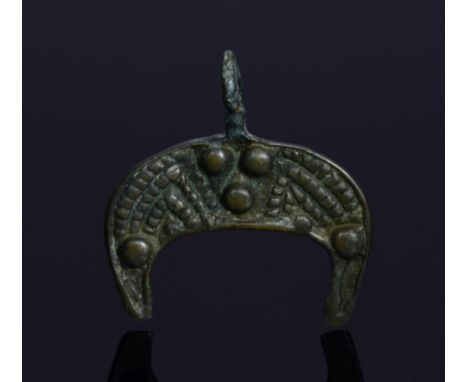 Interesting Medieval amulet shaped as moon crescent; well preserved integral loop; decorated with a stylized winged monster. 