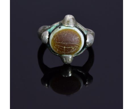 An interesting viking ring with agate stone in a cross shaped bezel; intact and well preserved band. The stone represents a s