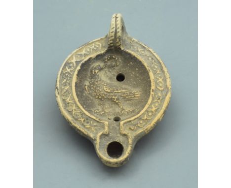 A terracotta oil lamp with an Eagle/bird holding a stylised wreath in mouth. A single nozzle to the front. - 110mm, 98 grams 